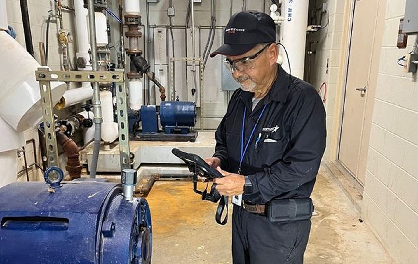 Aramark maintenance worker in a mechanical room at the university